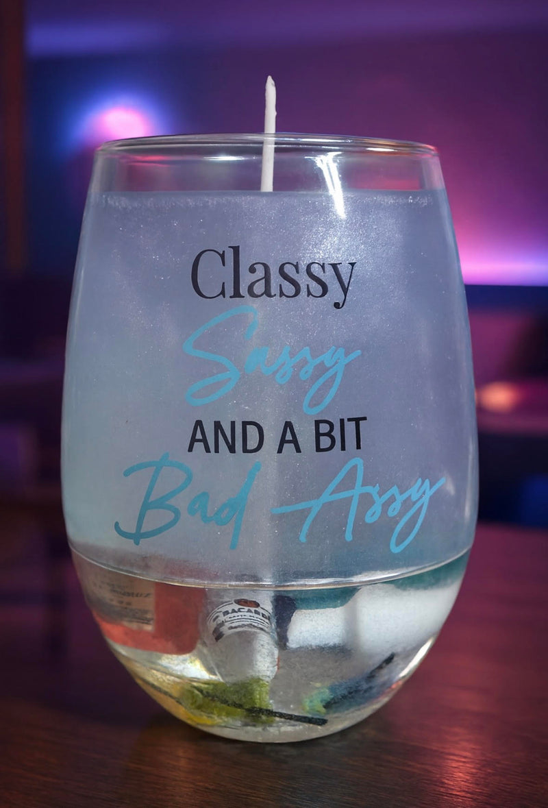 "Sassy" Liquor Candle      Handmade "sassy" liquor candle.  Bottom layer has drink glasses, second layer has  liquor bottles, both layers are covered in epoxy to preserve it.  The rest has light blue/silver gel wax in a "sassy" glass glass.